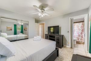 a bedroom with two beds and a flat screen tv at Cozy Patio Retreat by SkyRun Jacksonville in Sandalwood