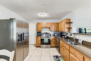 a kitchen with wooden cabinets and stainless steel appliances at Cozy Patio Retreat by SkyRun Jacksonville in Sandalwood