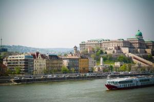 ein Boot auf einem Fluss vor einer Stadt in der Unterkunft Kahwa Apartments in Budapest
