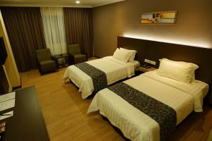 Postel nebo postele na pokoji v ubytování Hotel Anika Kluang