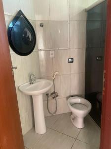 a bathroom with a sink and a toilet at Casa tamanho Família Aconchegante in Bauru
