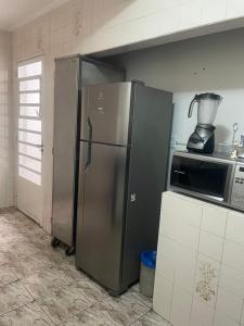a kitchen with a stainless steel refrigerator and a blender at Casa tamanho Família Aconchegante in Bauru