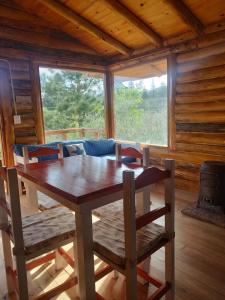 a dining room table and chairs in a cabin at Refugio Doña Josefa, cabaña de montaña La Cumbrecita in La Cumbrecita
