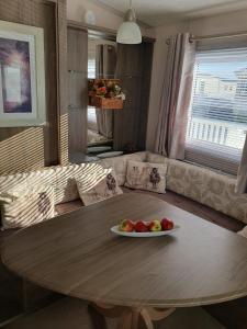 a wooden table with a plate of fruit on it at Hayling Island Caravan in Hayling Island