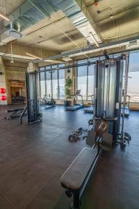a gym with treadmills and machines in a room with windows at Stylish Studio w Gym & Pool Access VIATO HOMES in Mexico City +14 photos