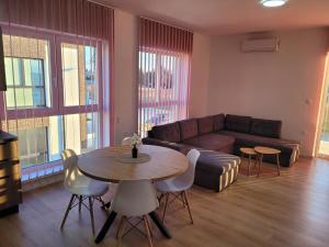 a living room with a couch and a table and chairs at Apartmán Neva Diakovce in Diakovce