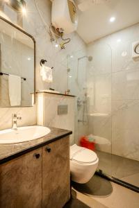 a bathroom with a toilet and a sink and a shower at Royal Studio Golf Course Road in Gurgaon