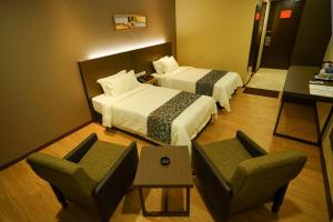 Postel nebo postele na pokoji v ubytování Hotel Anika Kluang