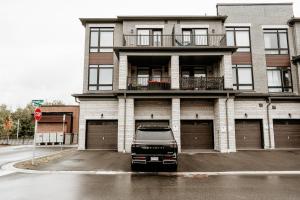 a truck parked in front of a building at Luxury 2-Bed Townhouse Near Waterfront & Downtown in Ajax