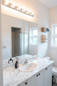 a white bathroom with a sink and a mirror at Luxury 2-Bed Townhouse Near Waterfront & Downtown in Ajax +46 photos