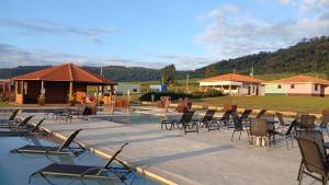 a group of chairs sitting on a patio next to a pool at Pousada Vila Caminito in Brotas