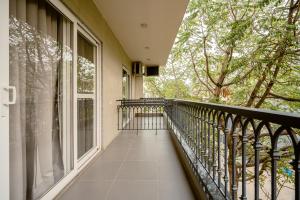 a balcony with a black railing and trees at Royal Studio Golf Course Road in Gurgaon