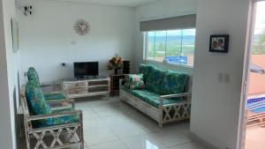 a living room with two chairs and a television at Terraço da Serra Flat - Casa em Serra Negra PE in Bezerros