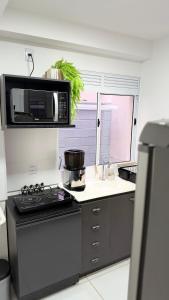 a kitchen with a stove and a microwave at Refúgio de Luxo in Montes Claros
