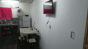 a white kitchen with a table and a refrigerator at Leo y mar in Mar de Ajó