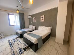 a hotel room with two beds and a rug at Breeze Apartment in Mombasa +27 photos