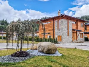 a statue of a tree in the grass in front of a building at Aquaterra Hot Spring Villa - Banya in Banya