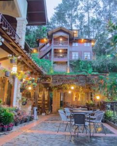un patio con mesas y sillas frente a una casa en Talita Mountain Resort, en Ciseureuh
