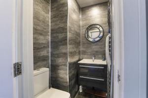 a bathroom with a toilet and a sink and a mirror at The Beach House - North East Escapes in Whitley Bay +24 photos