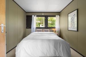 a large bed in a room with a window at Tomasjord home, the top floor in Trondalen