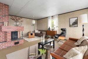 a living room with a couch and a fireplace at Tomasjord home, the top floor in Trondalen