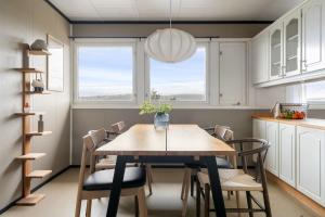 a kitchen and dining room with a table and chairs at Tomasjord home, the top floor in Trondalen +16 photos