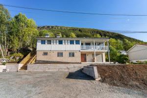 a house with a hill in the background at Tomasjord home, the top floor in Trondalen