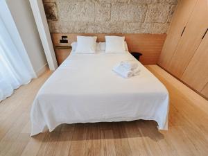 a bedroom with a white bed with towels on it at Apartamento Boutique/Progreso in Vigo