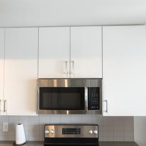 a kitchen with a microwave above a stove at Five Points South Spacious 2BR with 2 Queens in Birmingham