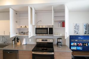 a kitchen with white cabinets and a black stove top oven at Five Points South Spacious 2BR with 2 Queens in Birmingham +9 photos