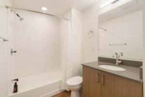 a bathroom with a sink and a toilet and a mirror at Five Points South Spacious 2BR with 2 Queens in Birmingham