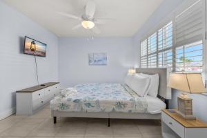 a bedroom with a bed and a ceiling fan at Renovated 2-Bedroom Condo with Pool - The Waves in St. Pete Beach +24 photos