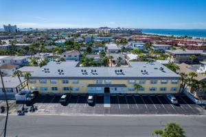 an aerial view of a large yellow building with a parking lot at Renovated 2-Bedroom Condo with Pool - The Waves in St. Pete Beach