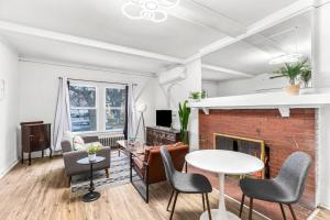 a living room with a brick fireplace and a table and chairs at Cozy Inn Holbrook NorthEnd in Hamtramck