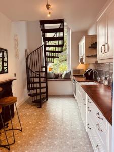 a kitchen with a spiral staircase in a kitchen at The Arches, Georgian Apartment in Cobh