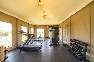 a gym with several treadmills and weights in a room at Olkupelia Mara in Talek