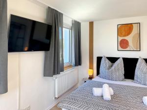 a bedroom with a bed with a flat screen tv on the wall at Apartment EverydayGood Erholung-Stadtnah-Anbindung-Einkauf-Biergarten in Salzweg