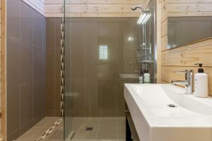 a bathroom with a glass shower and a sink at Still Water Retreat - beautiful lake front location and living in Waitahanui +60 photos