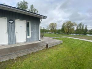 a house with a wooden deck next to a field at Practical Apartment for 2 in Smedsbacka