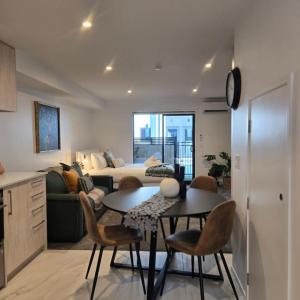 a living room with a couch and a table and chairs at Central Christchurch Studio - Allen Street in Linwood