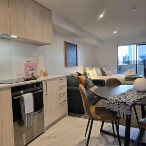 a kitchen and living room with a couch and a table at Central Christchurch Studio - Allen Street in Linwood +5 photos