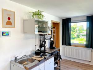 a small kitchen with a sink and a window at Apartment EverydayGood Erholung-Stadtnah-Anbindung-Einkauf-Biergarten in Salzweg