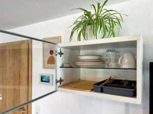 a white cabinet with a plant in it at Apartment EverydayGood Erholung-Stadtnah-Anbindung-Einkauf-Biergarten in Salzweg +17 photos