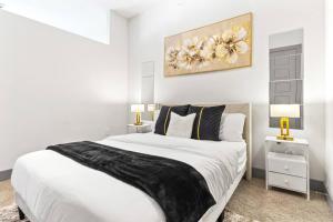 a white bedroom with a large bed and two lamps at Cozy Hideaway, Rooftop Pool, Gym, Shops nearby in Georgetown