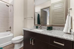 a bathroom with a sink and a toilet and a mirror at Modern Luxe Oasis, Rooftop Pool, Near Austin in Georgetown +21 photos