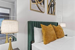 a bedroom with a bed with pillows and a lamp at Modern Luxe Oasis, Rooftop Pool, Near Austin in Georgetown