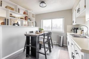 a kitchen with white cabinets and a black island with stools at Westlake Getaway Apartment in Westlake