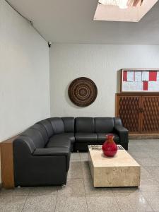 a black leather couch in a room with a table at Status Elegance Hotel in Serra +35 photos