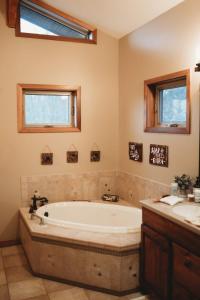a large bathroom with a tub and two windows at A-frame, Grand Views, Hot Tub, Mins To Boone & Asu in Sugar Grove