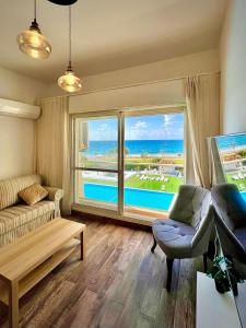 a living room with a couch and a view of the ocean at GW212 Gugel Waves Amazing Seaview Pool Apartments in Nahariyya